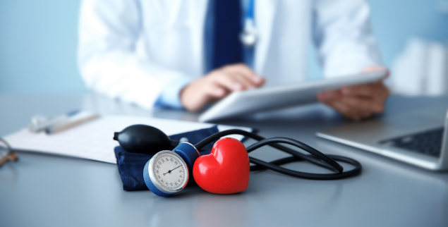 Doctor at Desk with blood pressure cuff
